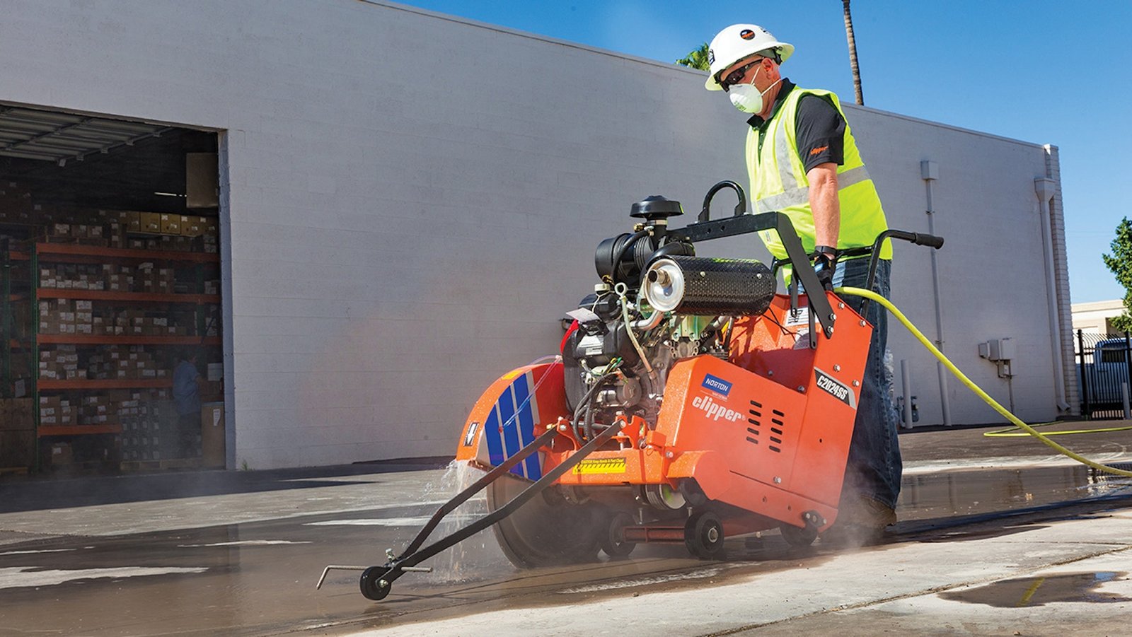 Track-mounted diamond wall saw cutting an opening in a reinforced concrete wall